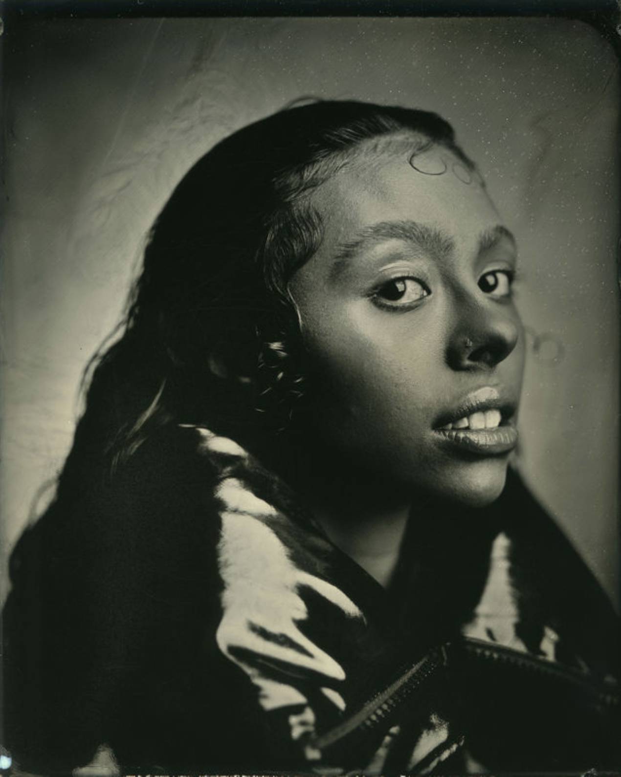 Tintype photograph of a woman in profile looking over her shoulder